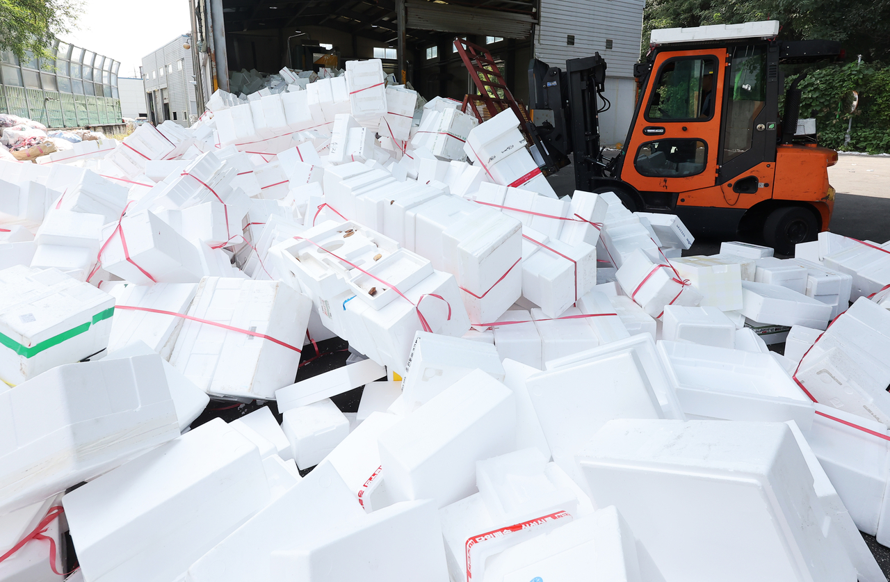 At a public recycling center in Yongin, Gyeonggi Province, workers on Monday sort through piles of foam boxes. (Yonhap)