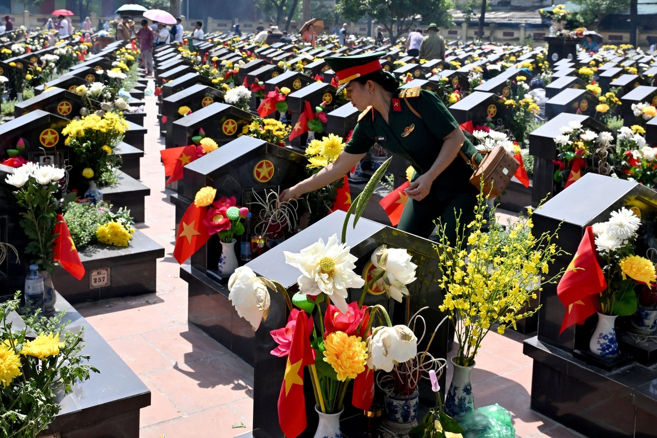 An army officer places an incense stick at the Ngoc Hoi Martyrs Cemetery in Hanoi on July 27, 2026, on Vietnam's War Invalids and Martyrs' Day. (Photo by Nhac NGUYEN / AFP)