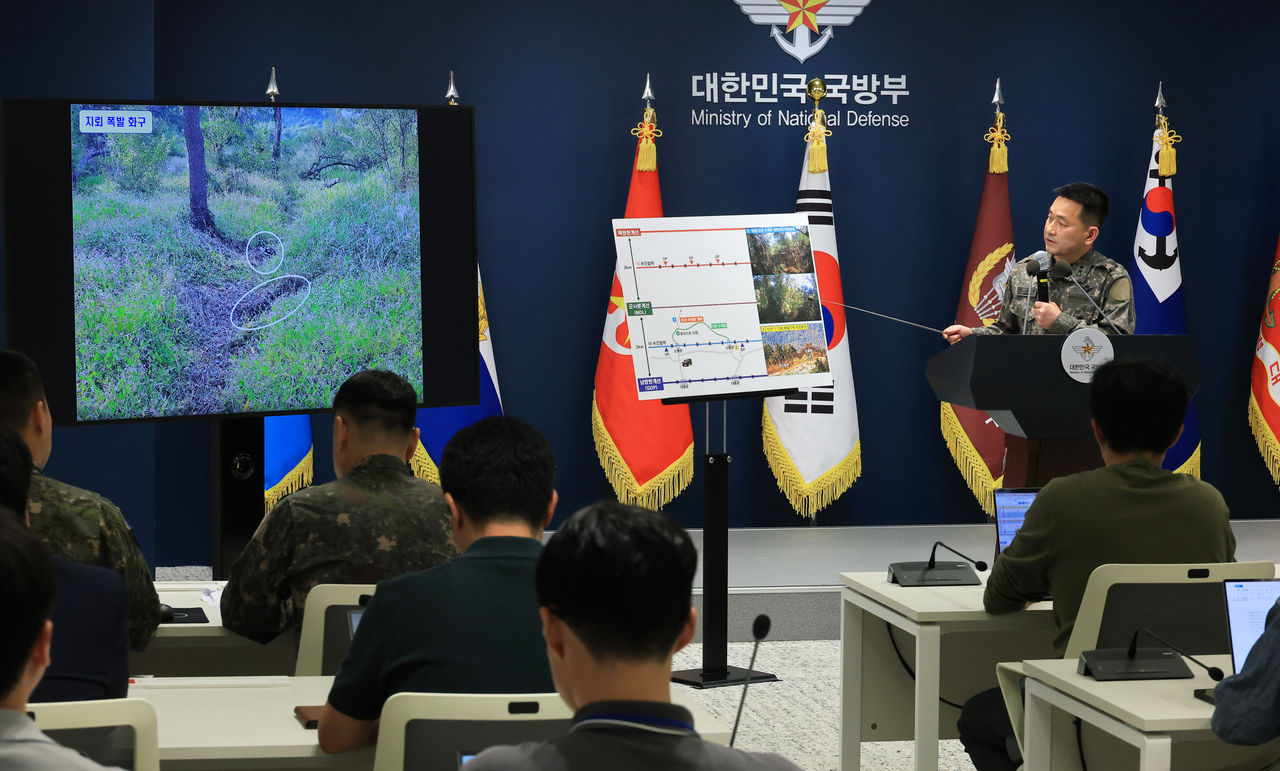 Army Maj. Gen. Yang Jin-hyuk (right), director of operations at the Joint Chiefs of Staff, explains terrain features and photographs related to the Sept. 21 DMZ mine explosions during a briefing at the Defense Ministry headquarters in Seoul on Monday. (Yonhap)