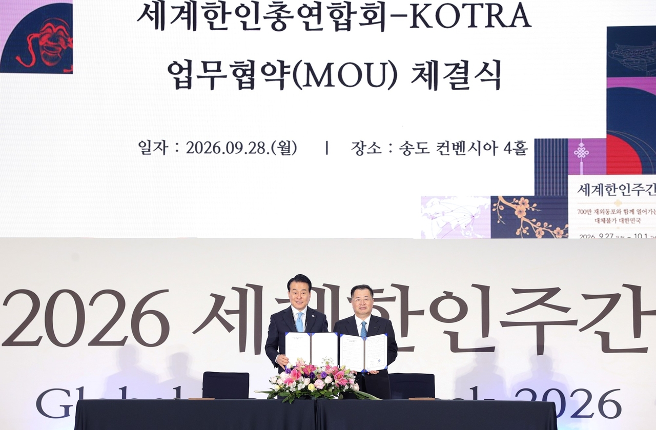 KOTRA President Kang Kyung-sung (right) and World Korean Alliance Chairman Ko Sang-gu (left) pose for a photo after signing an MOU to support Korean small and midsize companies' overseas expansion at Songdo Convensia in Incheon on Monday. [KOTRA]