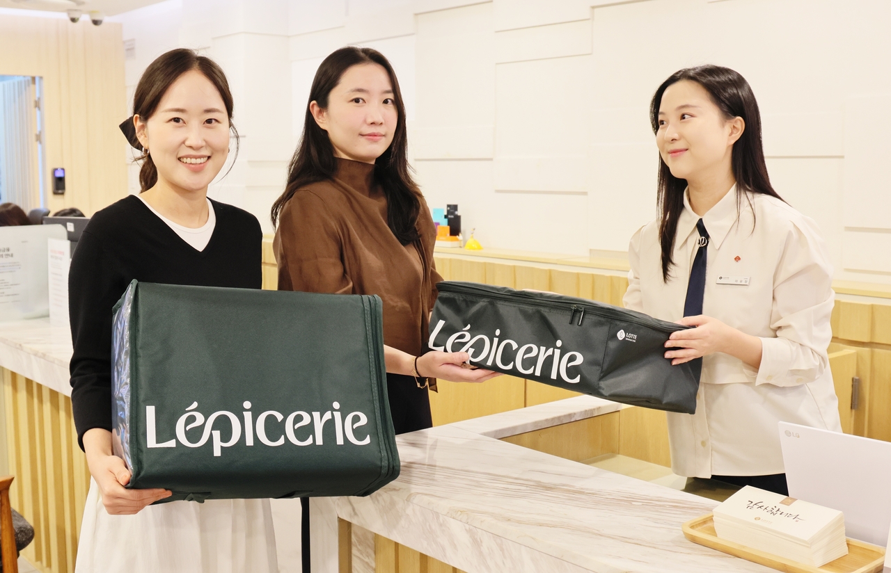 Staff at the gift-event hall on the 10th floor of Lotte Department Store's Daegu branch demonstrate the procedure for returning insulated bags and earning L.POINT credits ahead of the chuseok cooler-bag collection promotion. [Lotte Department Store]