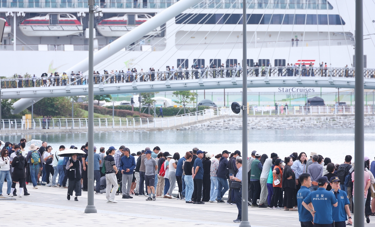 Crowds gather at North Port Waterfront Park in Dong-gu, Busan, on Tuesday morning to watch authorities guide a shark that had remained in the park’s waterway for 12 days, back to sea. (Yonhap)