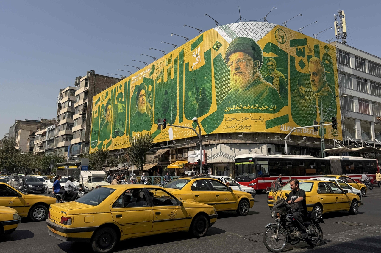 Iranians commute past a billboard depicting slain Lebanese Hezbollah leader Hassan Nasrallah and Iran's slain supreme leader Ayatollah Ali Khamenei in Tehran, Iran, Sunday. (AFP-Yonhap)