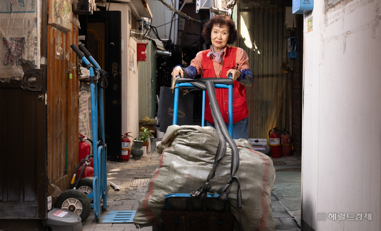 Sacks of empty cans and scrap materials are piled on the cart Na Jeong-hye pulls through the streets every morning and evening. She collects empty cans and bottles around the Jongno 3-ga area to make ends meet. (Yoon Chang-bin)