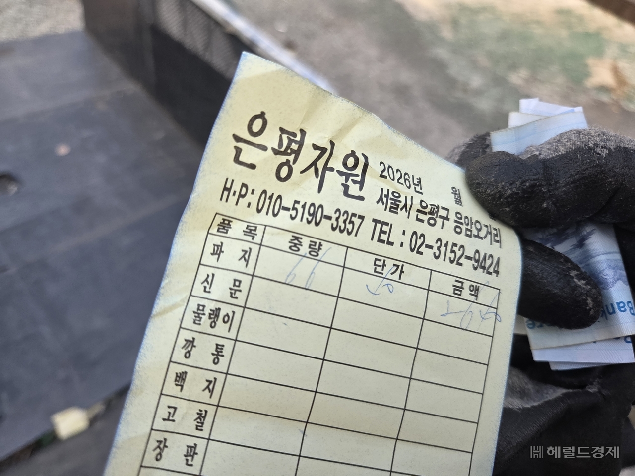 지난 22일 서울 은평구 한 자원순환시설에서 만난 양경자(82, 가명) 씨가 보여준 폐지 값. 66㎏를 수집해 2640원을 받았다. 정산서를 펴서 보여주는 경자 씨의 오른손에는 1000원이 쥐어져 있다. 이영기 기자