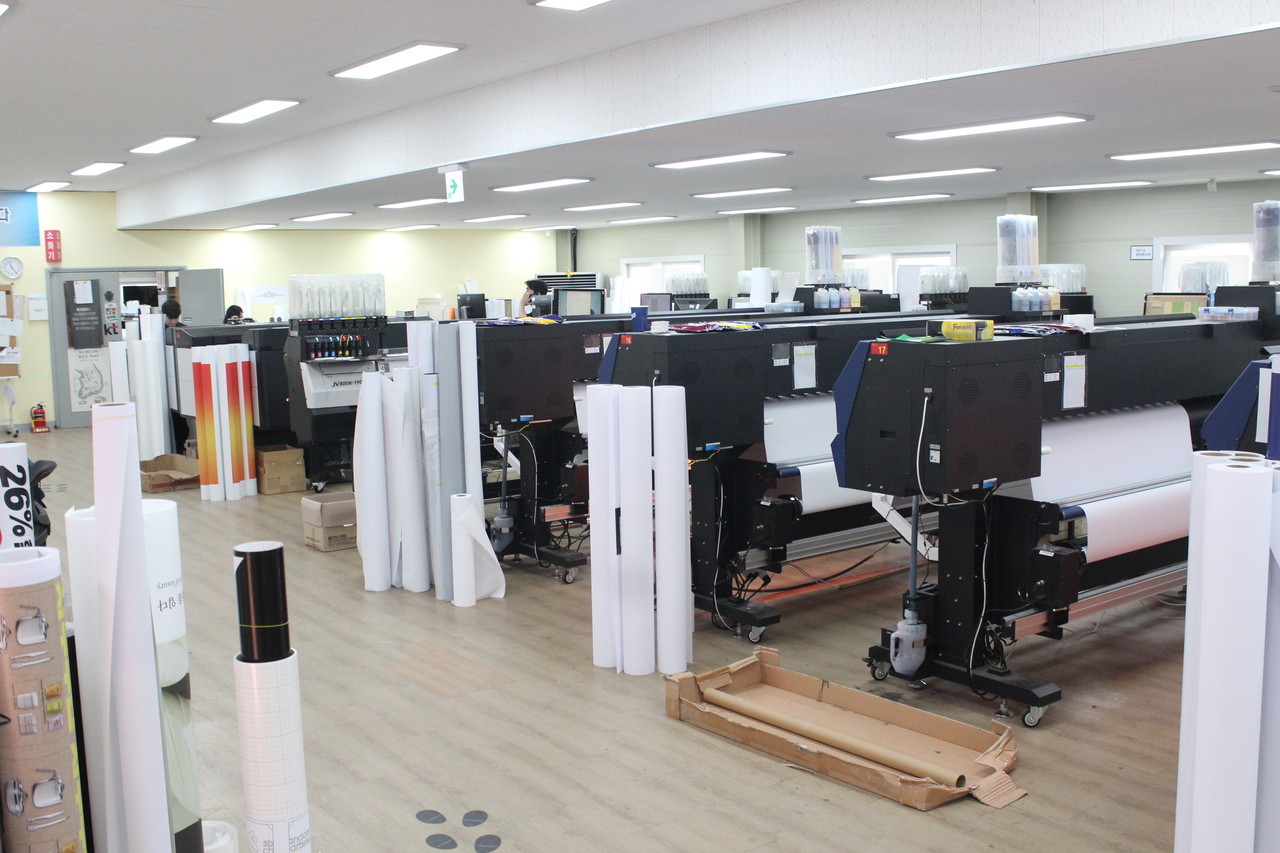 Large-format digital printers and hot-air dryers at Valuepoint, a business process outsourcing company. [iMarketKorea]