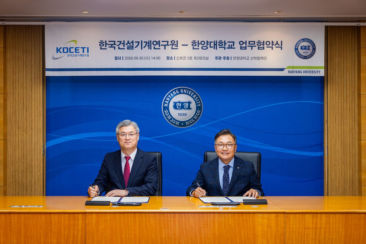 Korea Institute of Construction Machinery President Kim Jeong-dae (left) and Hanyang University Vice President for Research Ahn Jin-ho pose for a photo at the MOU signing ceremony held at Hanyang University in September 2026. [Korea Institute of Construction Machinery]