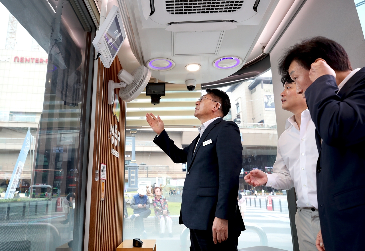Seongdong-gu District Mayor Yu Bo-hwa (far left) tries out a bus arrival announcement at a demonstration of the upgraded hearing loop system at a Seongdong-type smart shelter on Sept. 17. [Seongdong-gu]