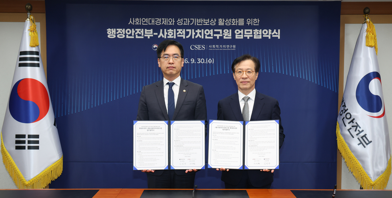 김민재(왼쪽) 행정안전부 차관과 나석권 SK 사회적가치연구원 대표이사가 30일 오전 서울 종로구 정부서울청사에서 사회연대경제 활성화를 위한 업무협약서에 서명한 뒤 기념촬영을 하고 있다. [행정안전부 제공]