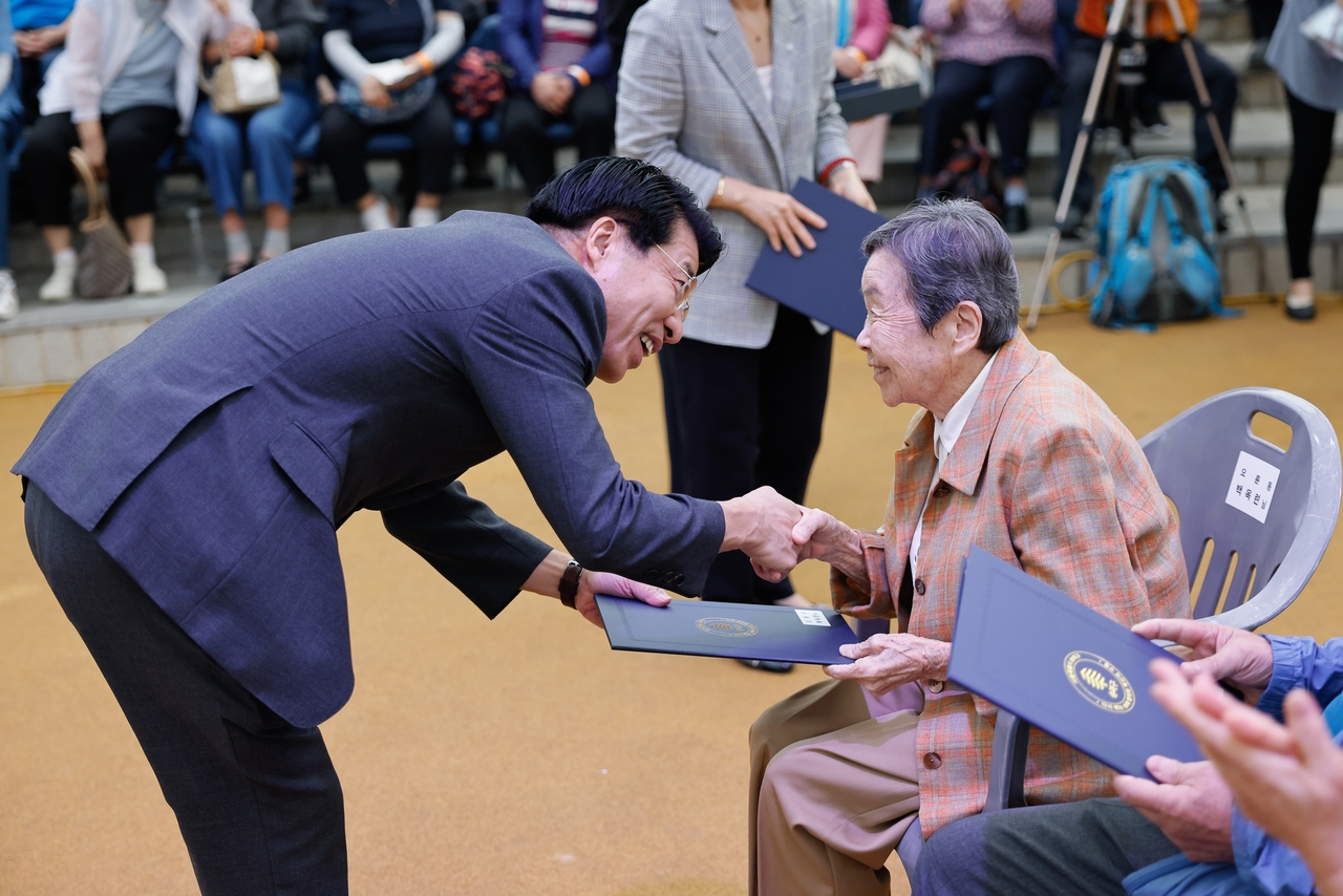 서강석 송파구청장이 모범 어르신에게 표창장을 주고 있다.