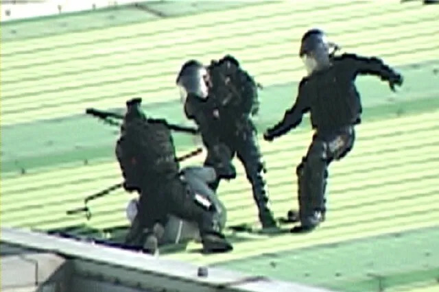 Police commandos beat a detained striker with batons on the roof of Ssangyong Motor's Pyeongtaek plant on Aug. 5, 2009. (National Human Rights Commission of Korea)