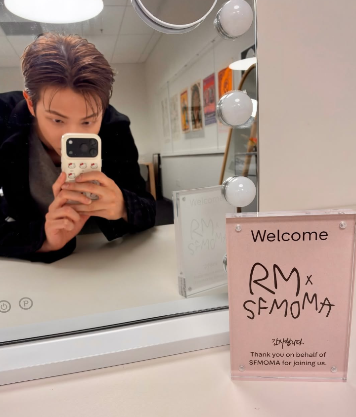 BTS’ RM poses with a welcome sign for “RM x SFMOMA: Between You and Me.” (Instagram)