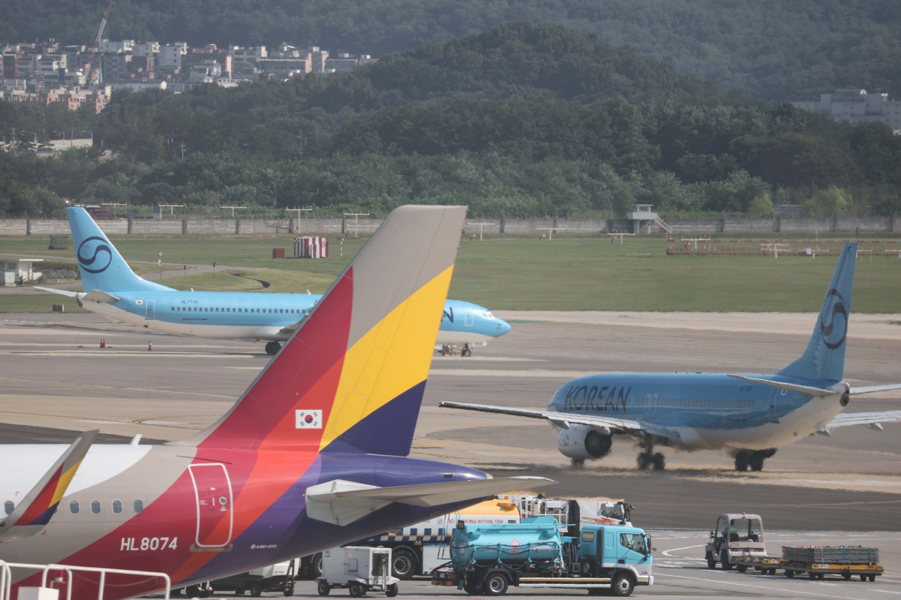 Korean Air and Asiana Airlines aircraft taxi on the apron at Gimpo Airport. [Yonhap]