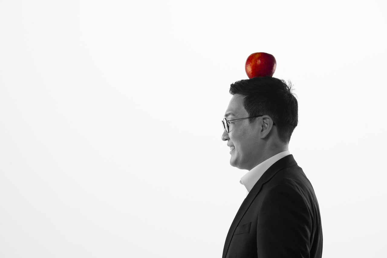 Chungju Mayor Lee Dong-seok poses before an interview with The Korea Herald at Herald Square in Yongsan-gu, Seoul, on Sept. 15. The apple on his head represents one of Chungju’s best-known local products. (Park Hae-mook/The Korea Herald)
