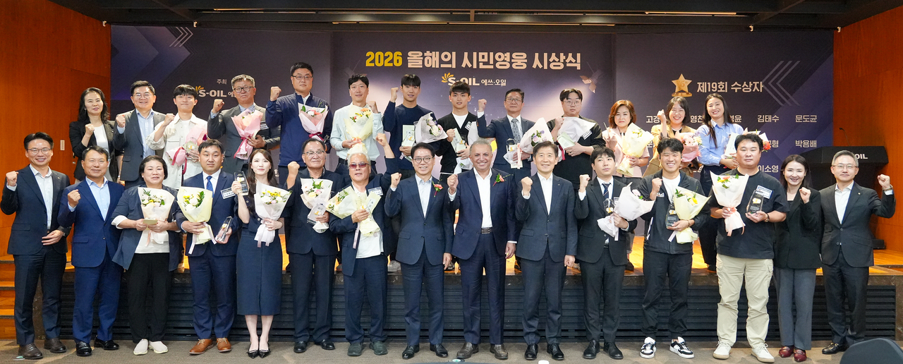 S-Oil CEO Anwar A. Al-Hejazi (seventh front right), S-Oil President Ryu Yull (six front right), Kim Hyun-hoon (eighth from right), chairman of the Korea National Council on Social Welfare, and award recipients pose for a photo during the 2026 Citizen Hero of the Year Awards at S-Oil headquarters in Mapo-gu, Seoul, on Thursday. (S-Oil)