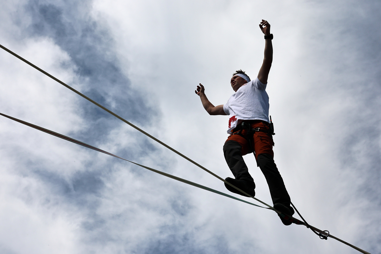 Jan Rus, a world-champion slackliner, performs above Sejong-daero in front of Cheonggye Plaza in Seoul on Thursday. [Yonhap]
