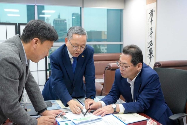 Suncheon Mayor Son Hun-mo (right) explains local issues to lawmaker Kim Moon-su (center) during a visit to the National Assembly on Wednesday.