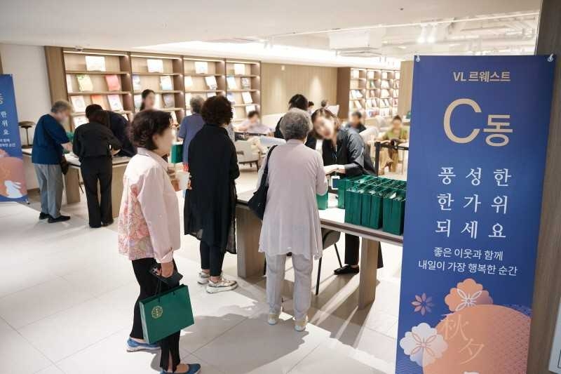 <VL르웨스트 입주민들이 지난 22일 커뮤니티센터 내 북라운지에서 열린 추석맞이 행사에 참석해 명절선물을 전달받고 있다.>