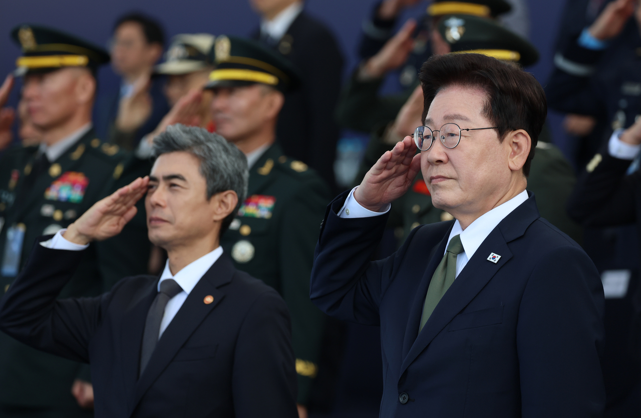 President Lee Jae Myung salutes the national flag alongside attendees during a ceremony marking the 78th Armed Forces Day at the Armed Forces headquarters in Gyeryong, South Chungcheong Province, Thursday. (Yonhap)