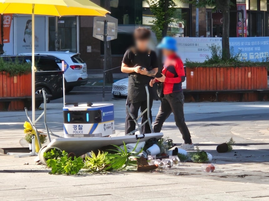 The autonomous patrol robot "Goyang Polybot" collides with a folding table holding flower pots at Hwajung Station Plaza in Goyang, Gyeonggi Province, on Monday. [SNS/Yonhap]