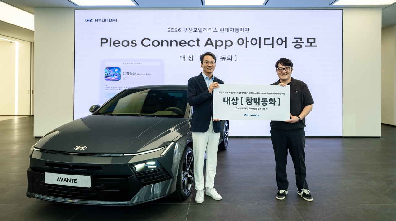 Hyundai Motor Senior Vice President and Domestic Marketing Division Head Lee Cheol-min (left) poses with Jeong I-deun, the grand prize winner of the Pleos Connect App Idea Contest, next to the All-New Avante — awarded as the grand prize — at Casper Studio in Busan on Wednesday. [Hyundai Motor]