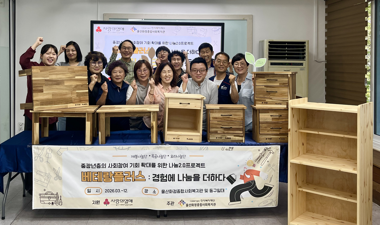 울산 동구 지역 중장년들로 구성된 목공나눔단이 직접 제작한 목공 제품을 지역의 취약계층에 전달하면서 기념촬영을 하고 있다. [울산화정종합사회복지관 제공]