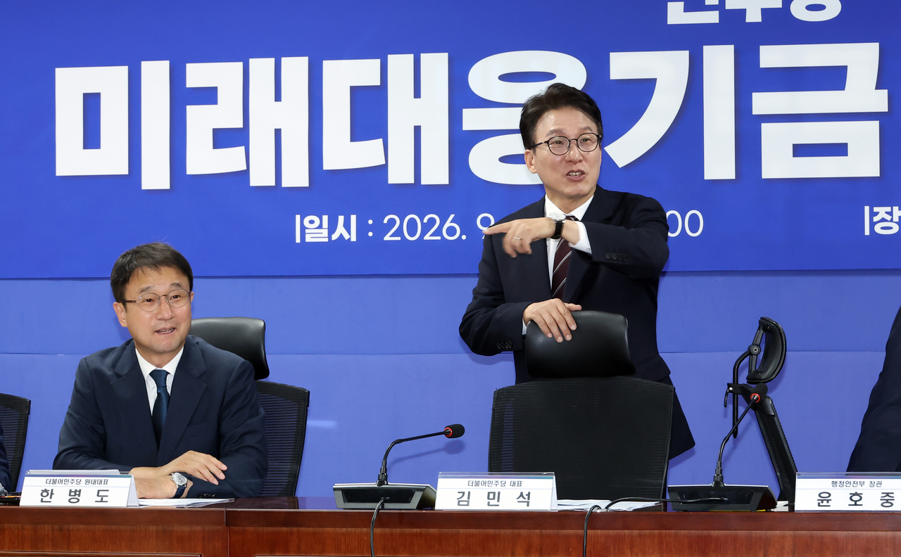 Democratic Party of Korea leader Kim Min-seok (right) and floor leader Han Byung-do attend a ruling party-government consultation on the future response fund at the National Assembly members' office building on Wednesday. [Yonhap]