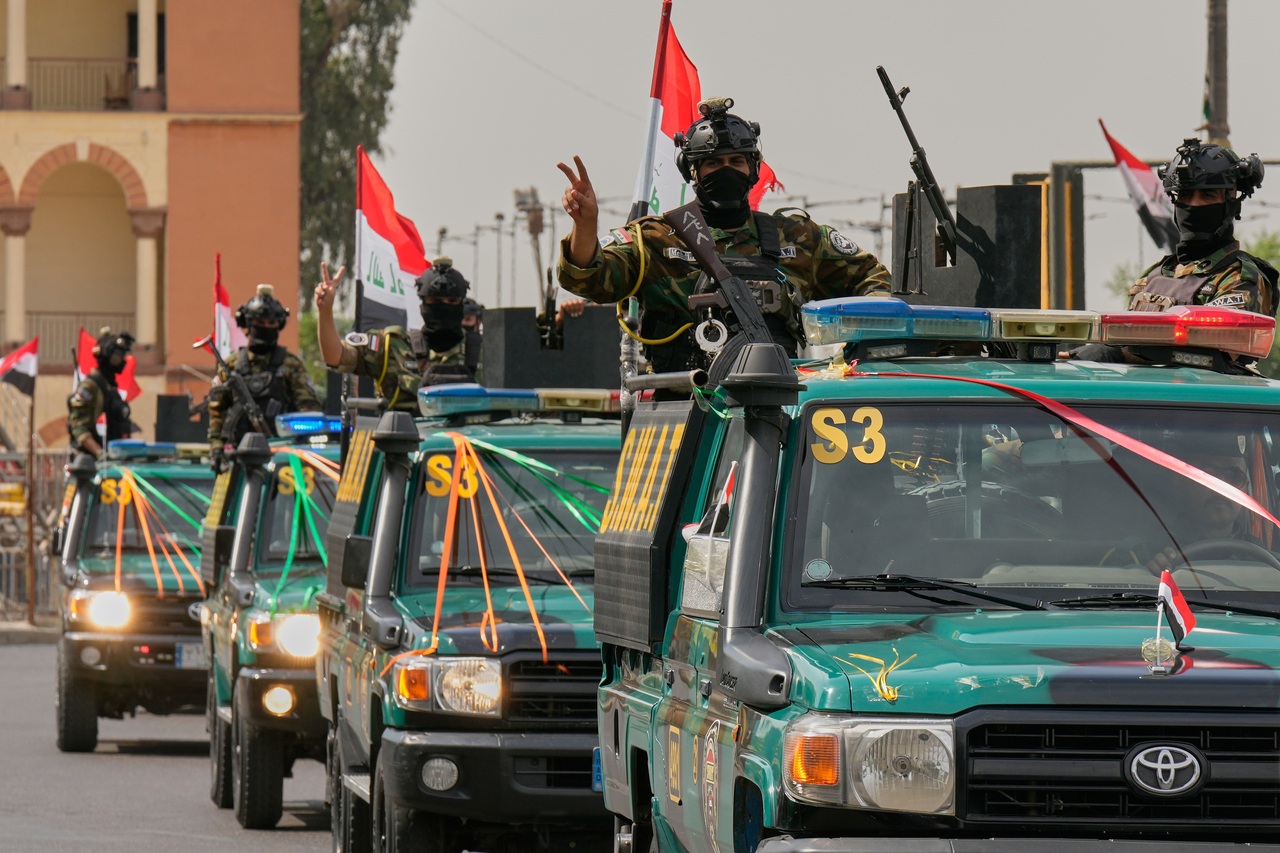 Iraqi security officers flash victory signs during a convoy in Baghdad, Wednesday. (AP-Yonhap)