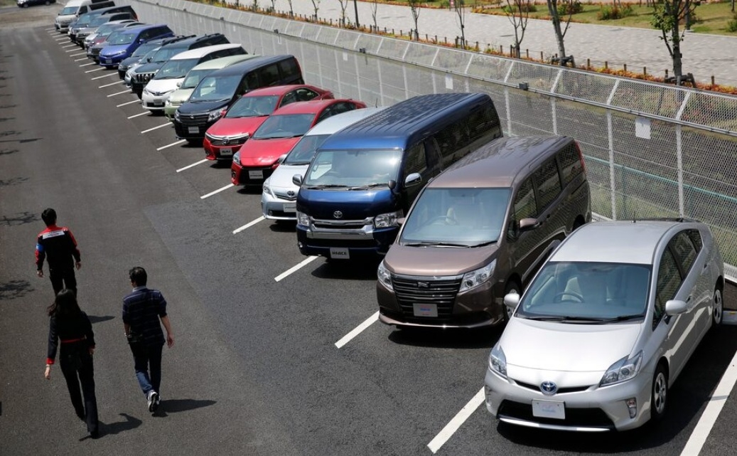 People walk past test-drive vehicles outside a Tokyo automaker showroom in 2014. [Reuters]