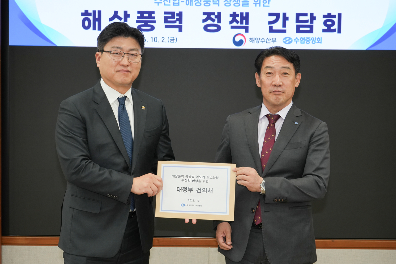 Choi Pil-jong, head of the Anchovy Drag-Net Fisheries Cooperative, hands a petition to Deputy Minister of Oceans and Fisheries Nam Jae-heon at an offshore wind energy policy forum held Friday at the National Federation of Fisheries Cooperatives headquarters. [National Federation of Fisheries Cooperatives]