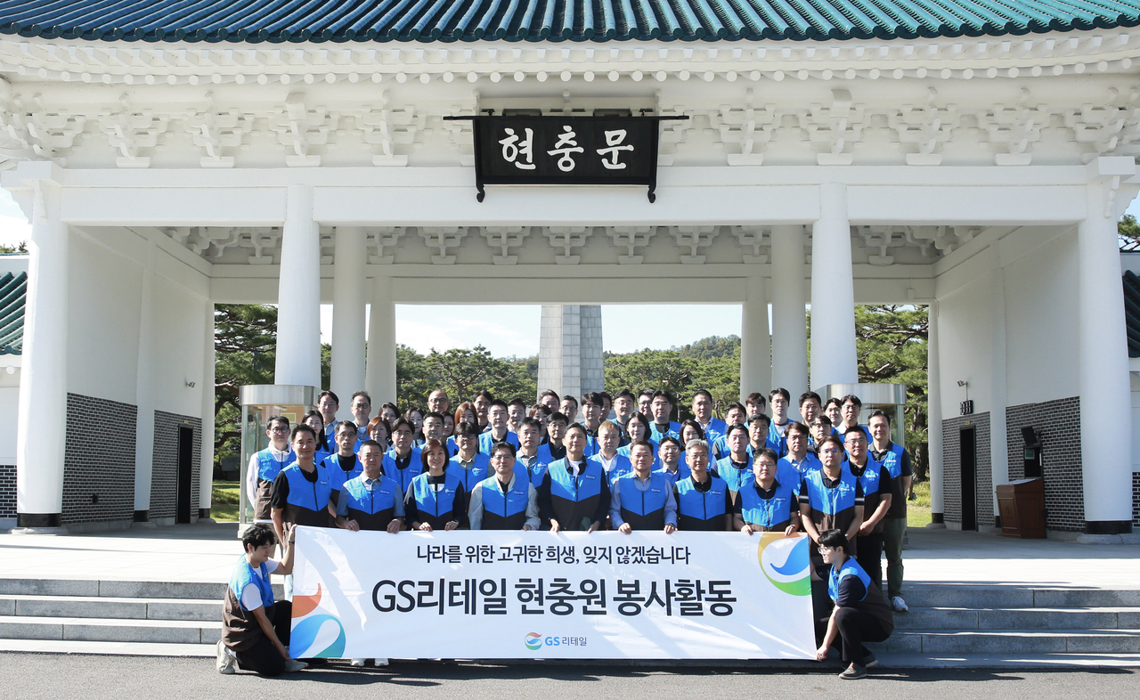 GS Retail CEO Heo Seo-hong (front row, fifth from left) and company executives pose for a group photo after a cemetery cleanup at Seoul National Cemetery on Thursday. [GS Retail]