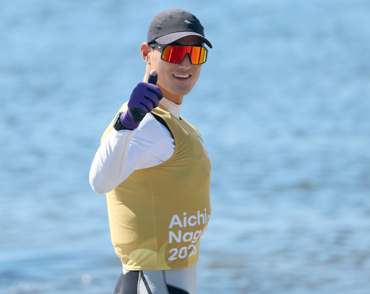 Ha Ji-min of South Korea waves before competing in the men's dinghy single-handed sailing event at the 2026 Aichi-Nagoya Asian Games at Gamagori Kaiyo Yacht Harbor in Aichi Prefecture, Japan, on Friday. [Yonhap]