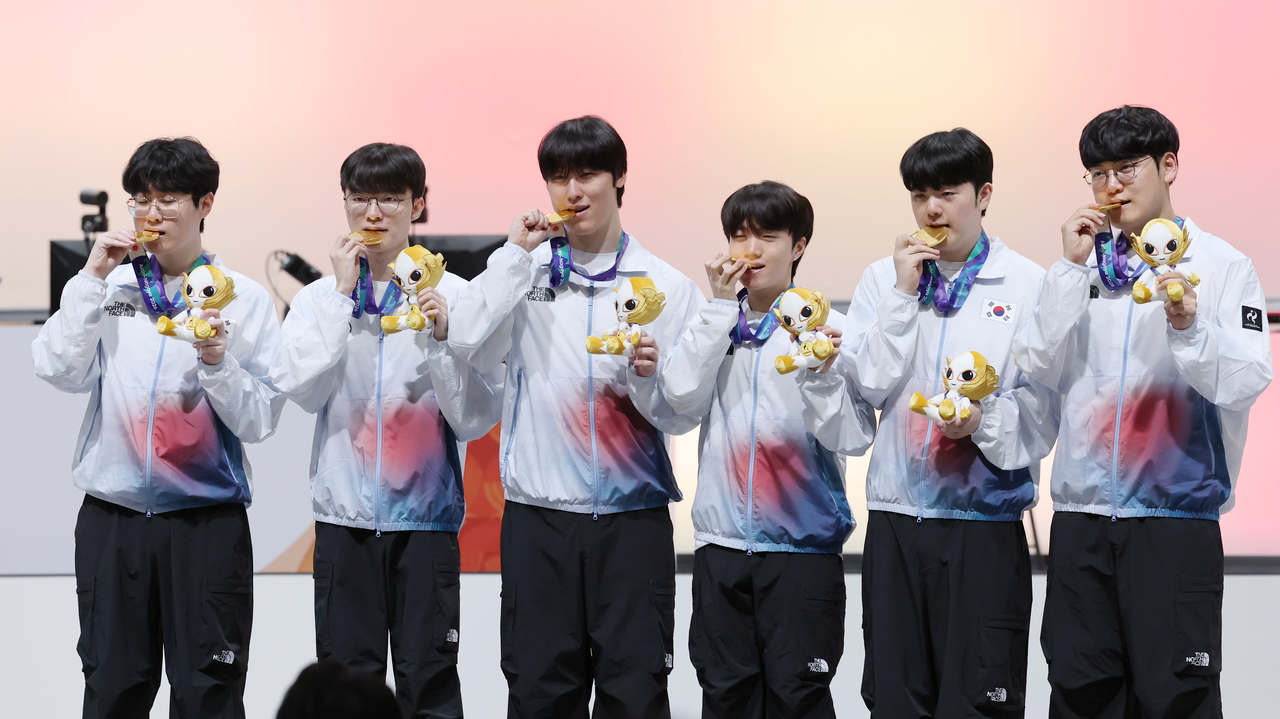 Members of the South Korean League of Legends team bite their gold medals won in the esports competition at the Aichi-Nagoya Asian Games at Aichi Sky Expo in Tokoname, Japan, on Friday. (Yonhap)