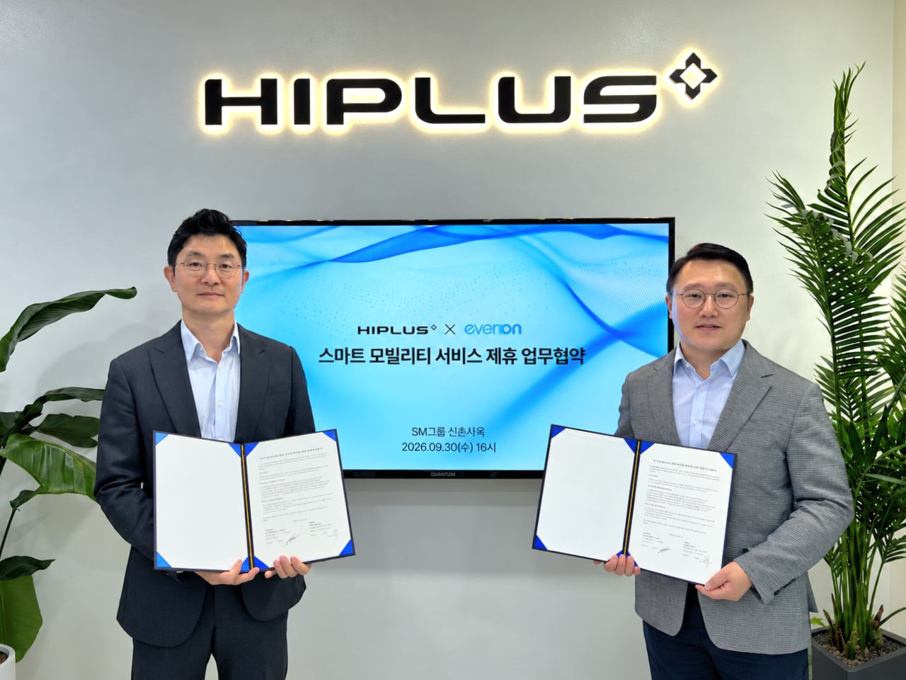 SM Hi-Plus CEO Ahn Byung-hyun (right) and Everon CEO Yoo Dong-su pose for a photo after signing an MOU for a smart mobility service partnership, including the launch of an EV Hi-Pass card, at SM Group's Sinchon headquarters in Seodaemun-gu, Seoul, on Wednesday.
