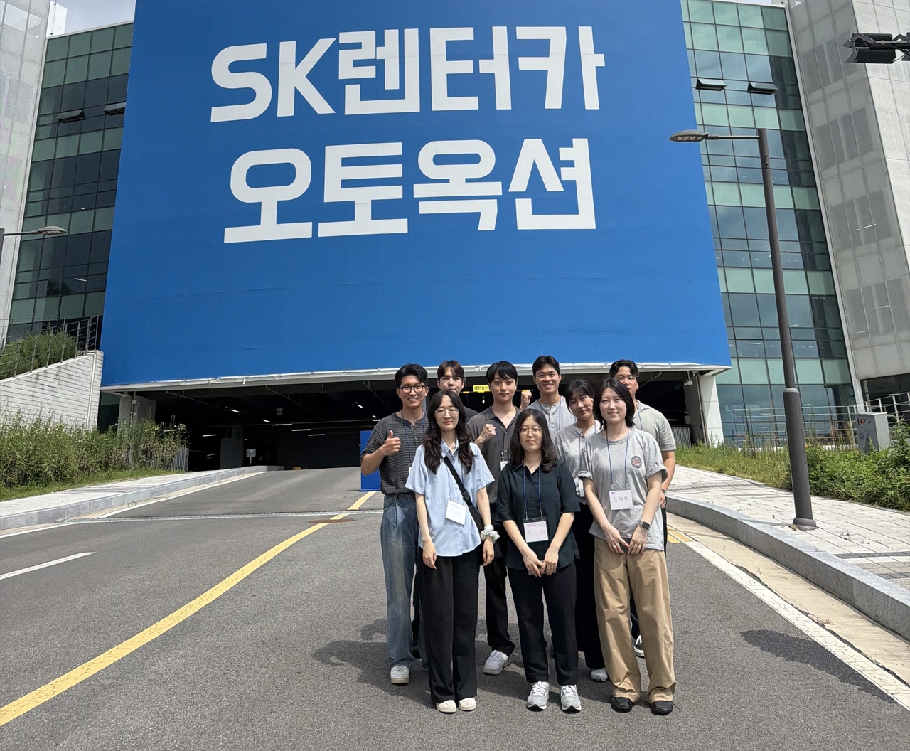 SK렌터카 하계 인턴십 참가자들이 대표적인 현장 체험 프로그램 중 하나로 천안 오토옥션을 방문해 실시간 중고차 경매 과정을 견학한 뒤 기념 촬영을 하고 있다. [SK렌터카 제공]
