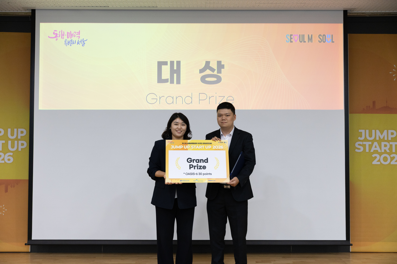 The top-prize winner from NeuroDetectYO poses with an award presenter at the “Jump Up, Start Up 2026” competition at the Seoul Global Center on Wednesday. (Seoul Metropolitan Government)