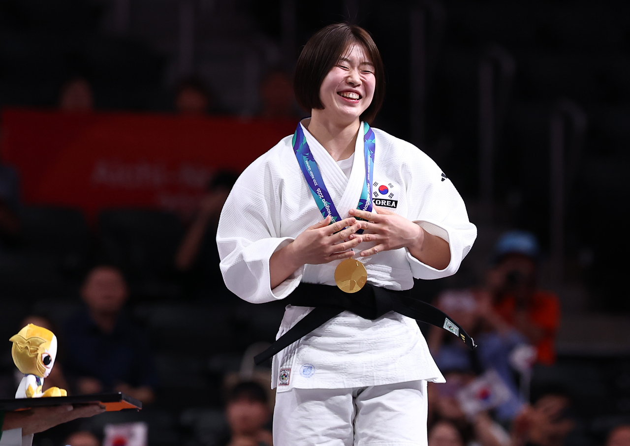 Heo Mimi smiles on the podium after winning the gold medal in the women's under-57-kilogram judo event at the 2026 Aichi-Nagoya Asian Games at Aichi International Arena in Nagoya, Japan, on Thursday. [Yonhap]