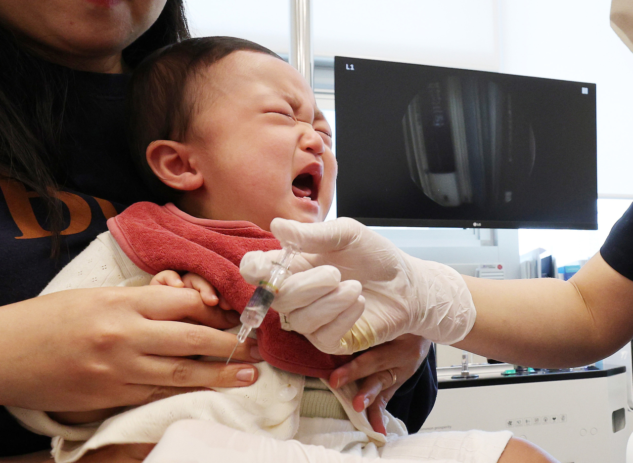 A child receives an influenza vaccine at a pediatric clinic in Yeongtong-gu, Suwon, Gyeonggi Province, on Sept. 21, as the national free vaccination program kicked off for children and pregnant women. According to the KDCA, the program will roll out sequentially — starting with children aged 6 months to 14 years and pregnant women — before extending to adults 65 and older next month.