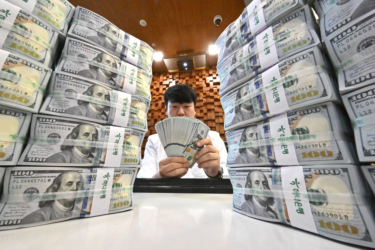 An employee examines dollar bills at Hana Bank's counterfeit response center in Jung-gu, Seoul. [Herald DB]