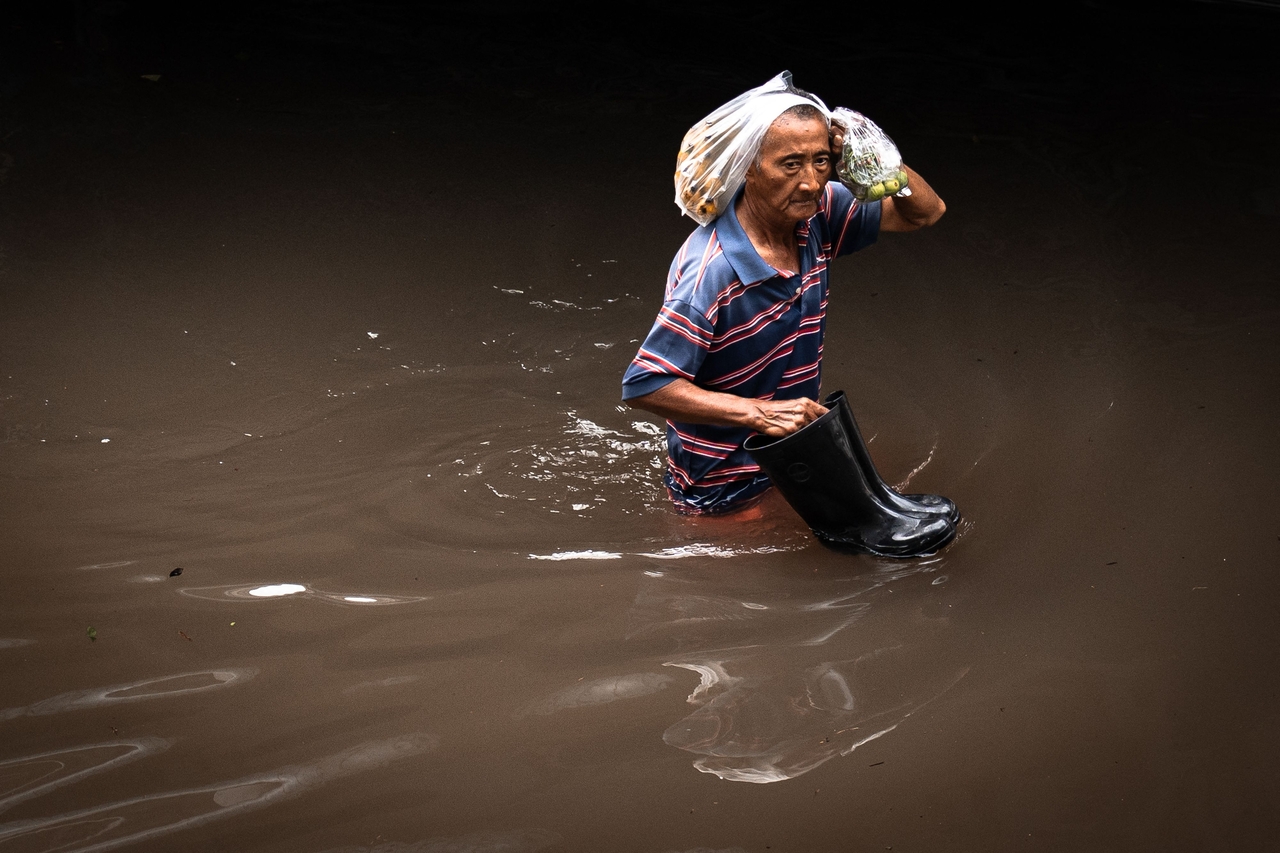 A man walks through floodwaters in the Bang Kapi district of Bangkok on September 28. (AFP)