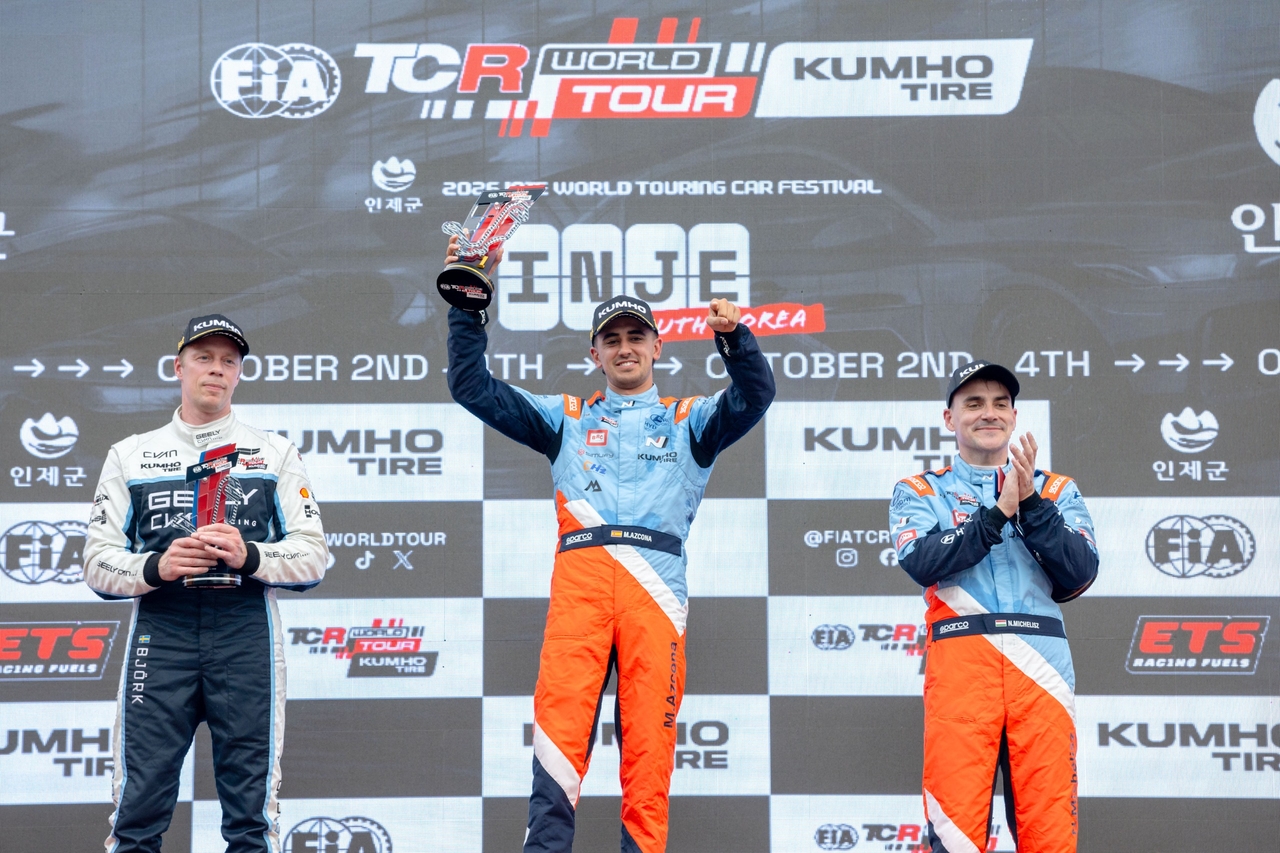 Mikel Azcona (center) holds his trophy on the podium after winning first place. [Hyundai Motor]