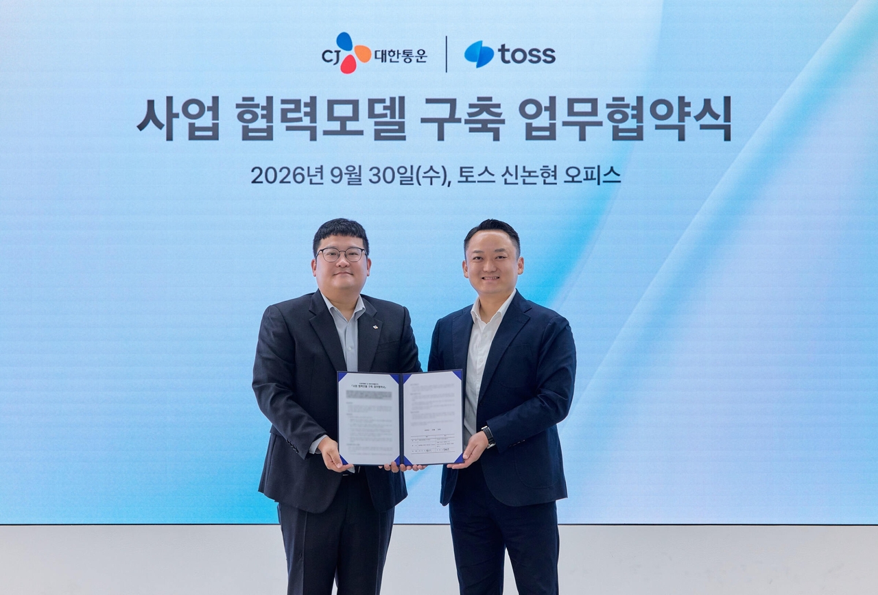 Jung In-ji, head of planning at CJ Logistics' O-NE division (left), and Jin Pil-gyu, head of Toss's payment business division, pose for a photo at a signing ceremony held at Toss's Sinnonhyeon office in Seocho-gu, Seoul, on Wednesday. [CJ Logistics]