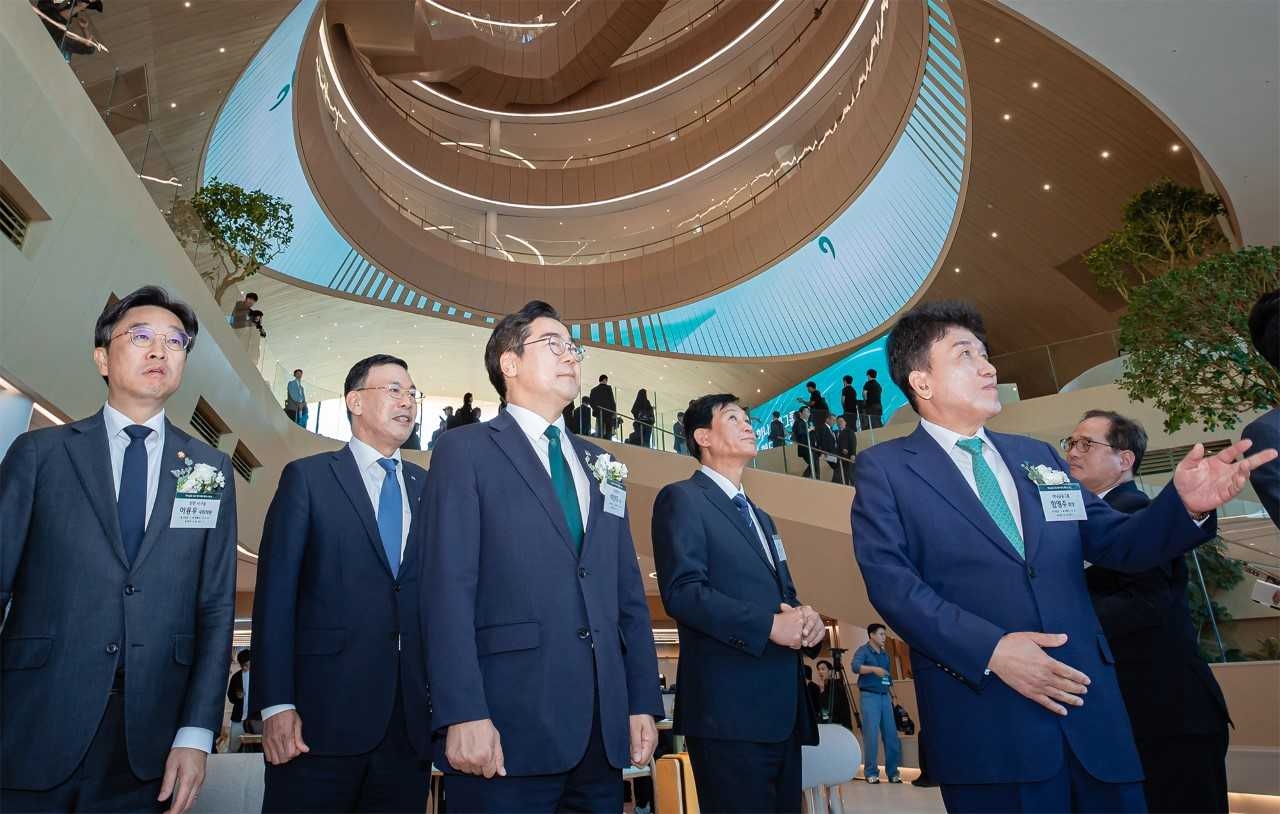 Hana Financial Group Chairman Ham Young-joo (front row, right) introduces the interior of the group’s new Cheongna headquarters to Incheon Mayor Park Chan-dae (front row, center) and other guests during its opening ceremony Friday. (Hana Financial Group)