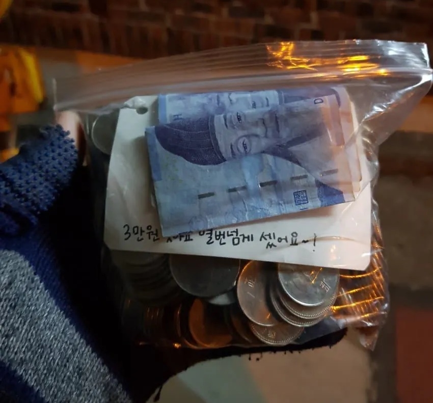 This photo attached to an online post shows a bag of change, apparently left as payment for a pizza delivery. The person who wrote the post said he recently made the delivery in an impoverished part of Seoul, and decided not to take the money. (Instagram)