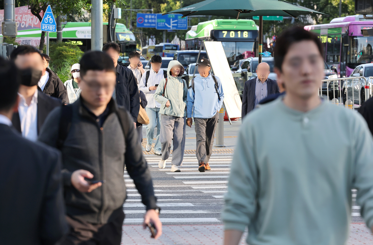 지난 1일 오전 서울 종로구 광화문거리에서 쌀쌀해진 날씨 속에 시민들이 출근하고 있다. [연합]