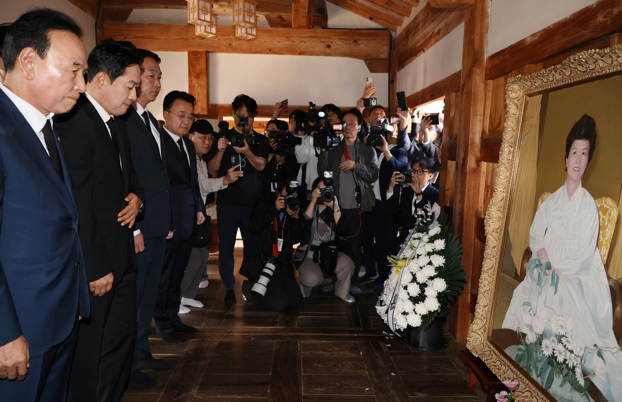 People Power Party Reps. Jang Dong-hyeok (second from left) and Park Duk-hyum (left) pay their respects to ex-first lady Yuk Young-soo in a visit to her birthplace in Okcheon-gun, North Chungcheong Province, on Monday. (Yonhap)