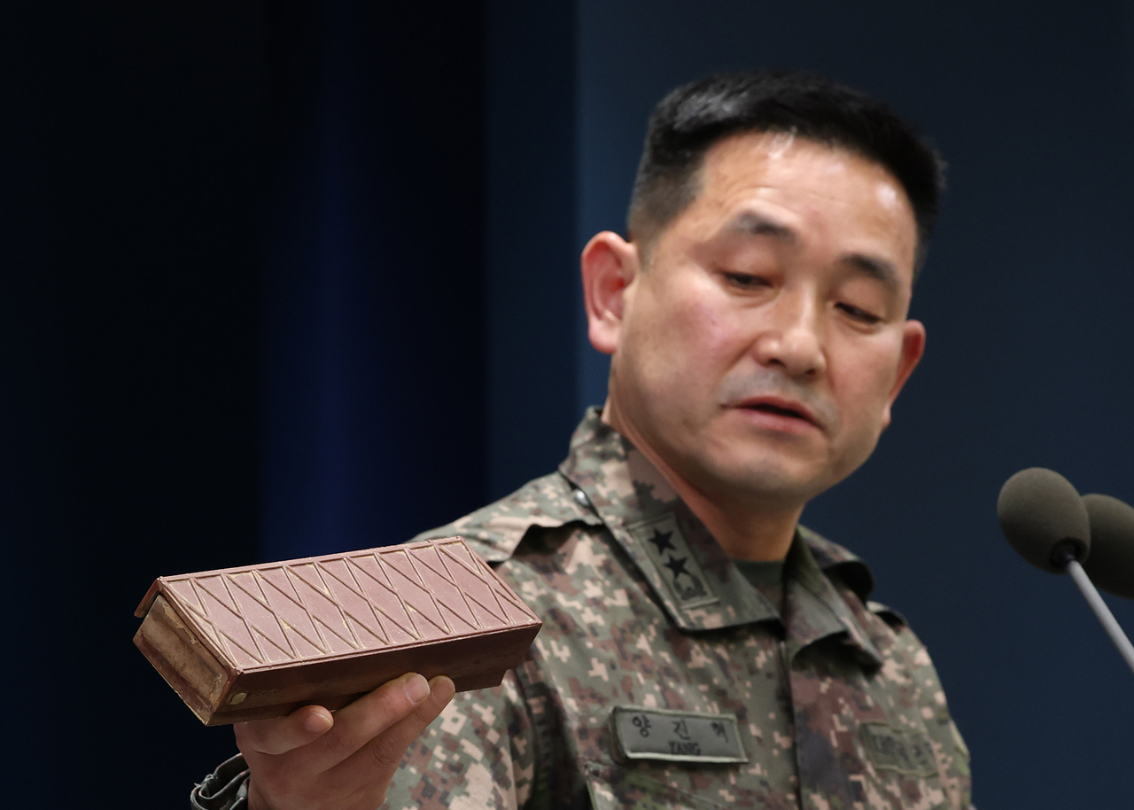 Yang Jin-hyeok, operations chief of the Joint Chiefs of Staff, holds up a plastic antipersonnel mine recovered in a previous operation during a briefing Monday at South Korea's Ministry of National Defense in Yongsan-gu, Seoul, where the joint field investigation task force announced its final findings on the DMZ mine explosion. (Yonhap)