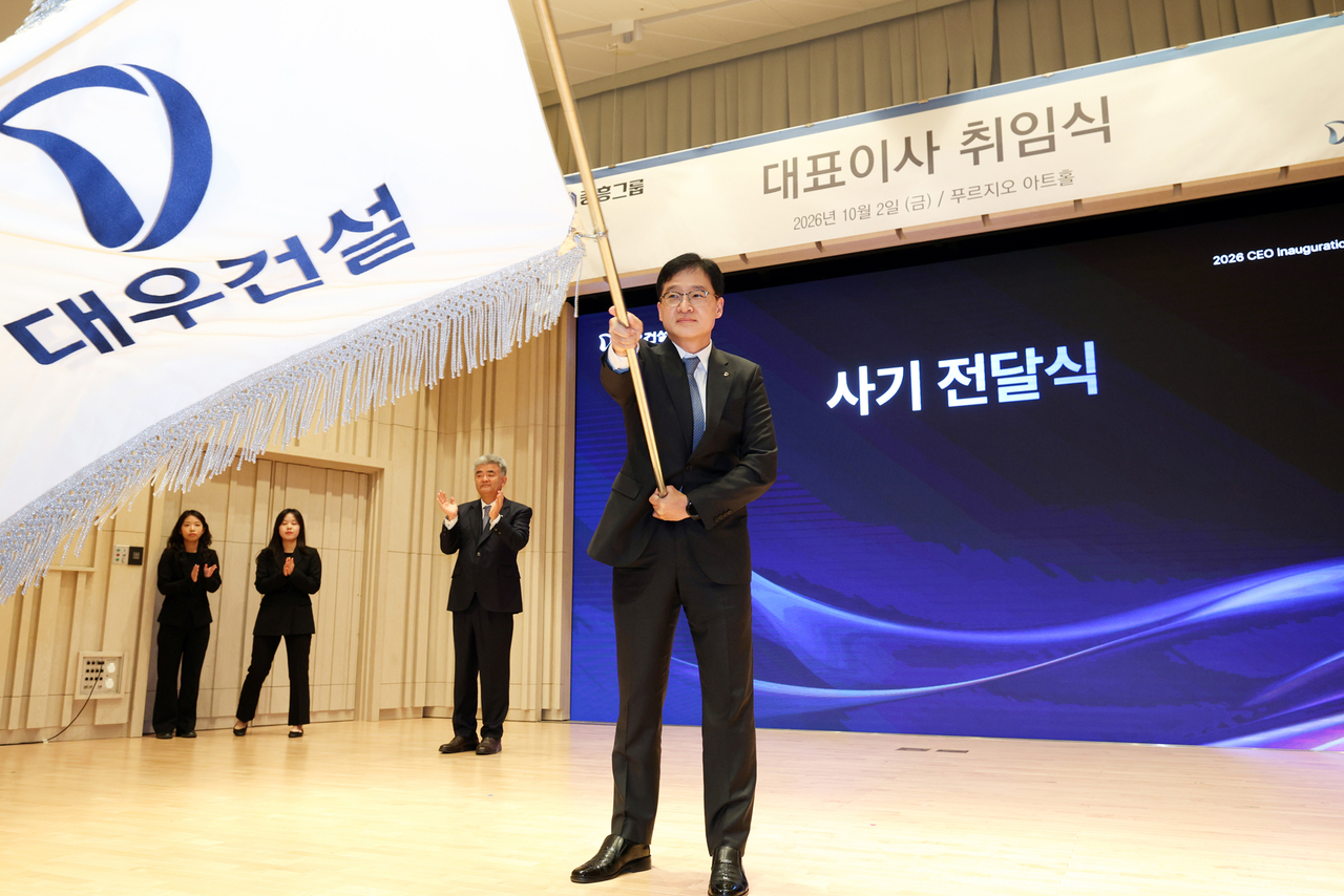 이강석 대우건설 대표이사가 2일 서울 을지로 본사 푸르지오 아트홀에서 열린 취임식에서 정원주(왼쪽 세 번째) 회장의 박수를 받으며 사기를 흔들고 있다.  [대우건설 제공]