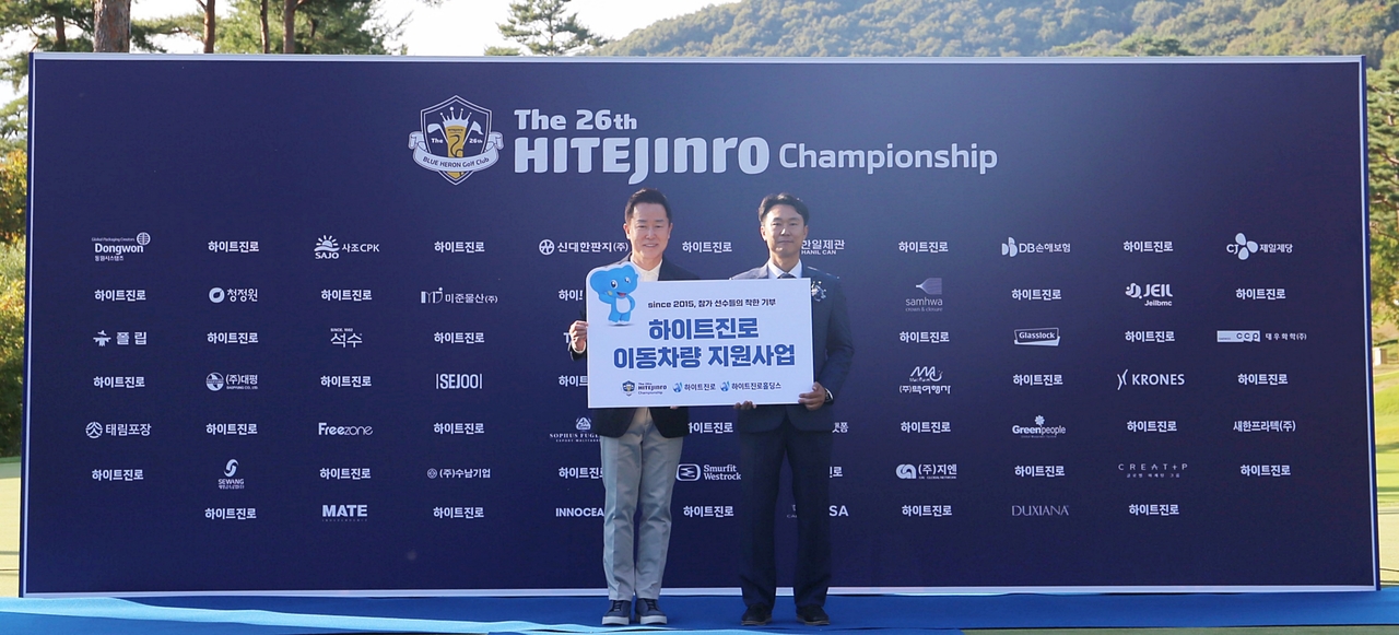 하이트진로와 하이트진로홀딩스가 지난 4일 경기 여주시 블루헤런GC에서 열린 ‘제26회 하이트진로 챔피언십’ 종료 후 이동차량 전달식을 진행했다. 장인섭(왼쪽) 하이트진로 대표이사와 이대호 직업재능개발센터장이 기념촬영을 하고 있다. [하이트진로 제공]
