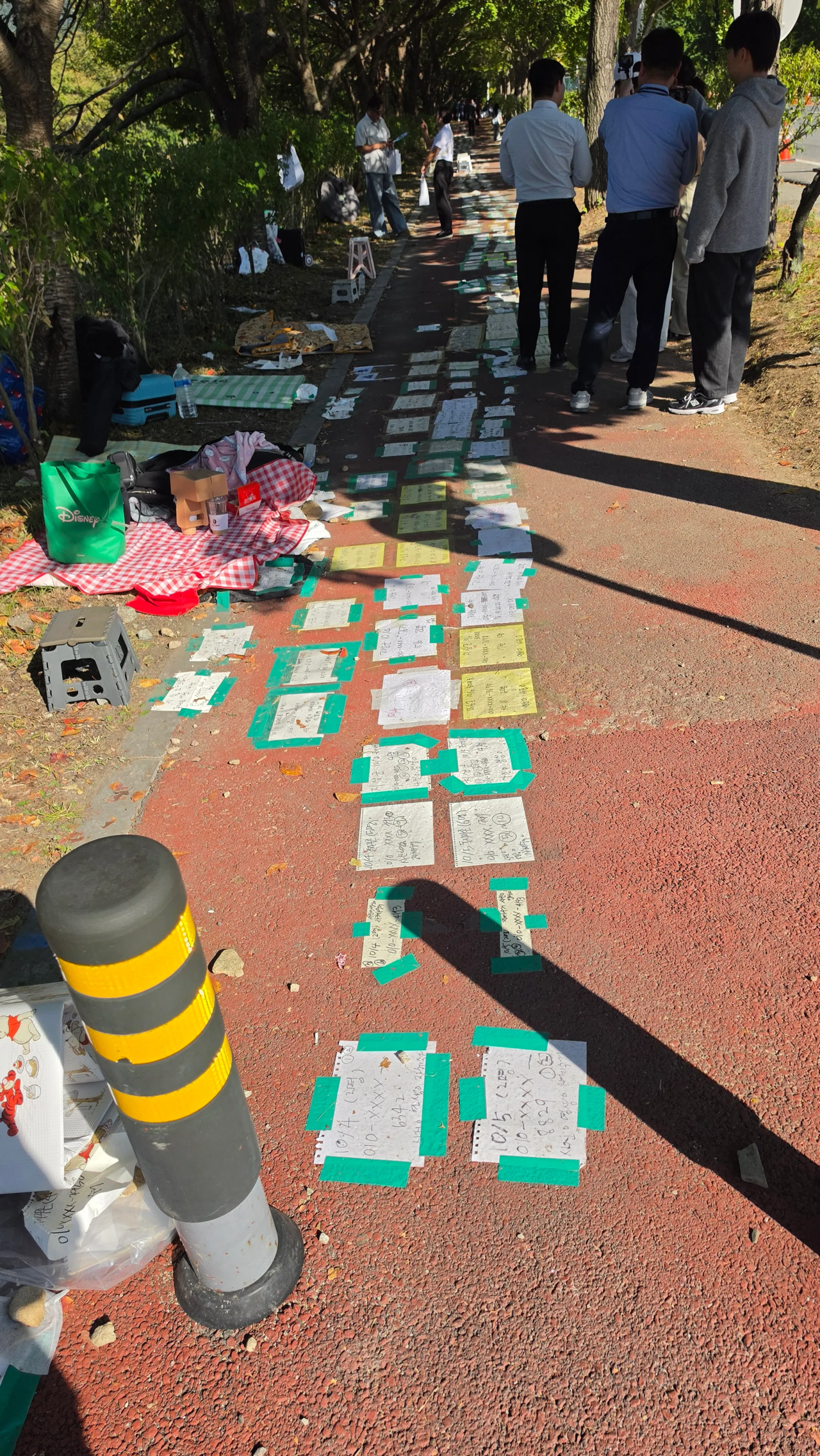 Sheets of paper marking spots in a queue are seen along a sidewalk near the 2026 Ground Forces Festival at the Gyeryongdae military airfield in South Chungcheong Province on Sunday. (X)